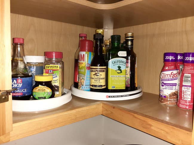 Two lazy susan turntables in a reviewers cabinet filled with items