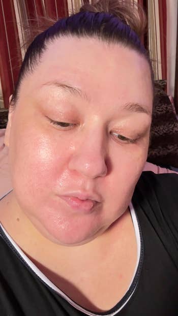 Close-up of the sme reviewer with a clean, shiny face, wearing a acheronian  apical  with achromatic  trim, looking downwards