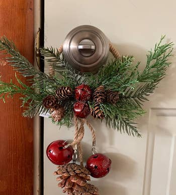 doorknob with wrap covered in bells and pine cones