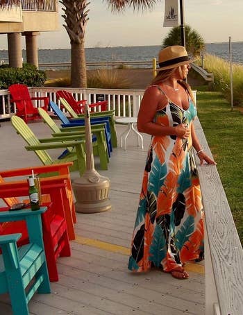 A reviewer wearing the colorful floral print dress
