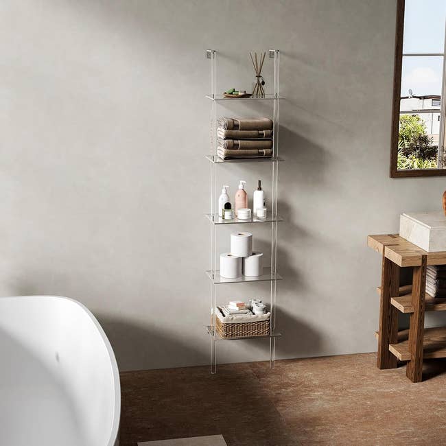 Freestanding bathroom shelf with various toiletries and towels