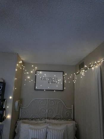 Bedroom with drawstring lights, a decorative robust bed, and a framed