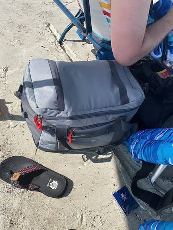 reviewer image of the cooler bag resting on a sandy beach