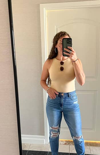 reviewer wearing the tan bodysuit with jeans