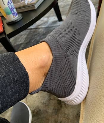 reviewer wearing the gray slip-ons