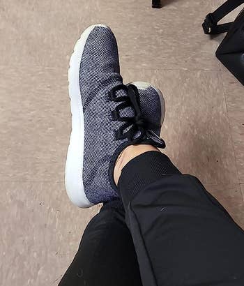 reviewer wearing the black and white sneakers
