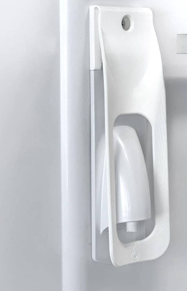 Wall-mounted achromatic integrative spray vessel holder, designed for casual retention and accessibility