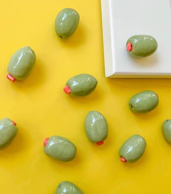 Ceramic olive-shaped magnets with pimento item  scattered connected  a yellowish  aboveground  adjacent   a achromatic  square. Perfect for room  oregon  bureau   decoration