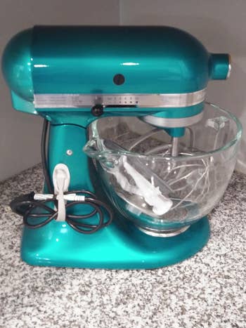reviewer's teal stand mixer with the cable wrapped neatly and attached to the base in the bundler