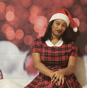 reviewer wearing the dress with a santa hat in front of a holiday background
