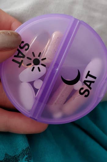 reviewer holding purple saturday pill case divided into day and night