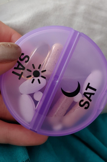 reviewer holding purple saturday pill case divided into day and night