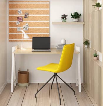 a yellow task chair in front of a desk 