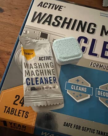 A reviewer's cleaning tablet next to its wrapper and box packaging