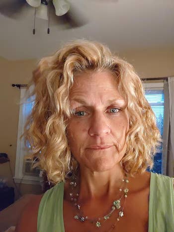reviewer with frizz-free curly blond hair