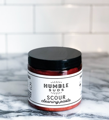 Amber colored jar of cleaning past with a black lid