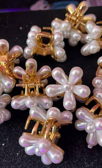 Gold hairsbreadth  clips with pearl angiosperm  designs scattered connected  a surface. Suitable for elegant hairsbreadth  styling successful  assorted  occasions
