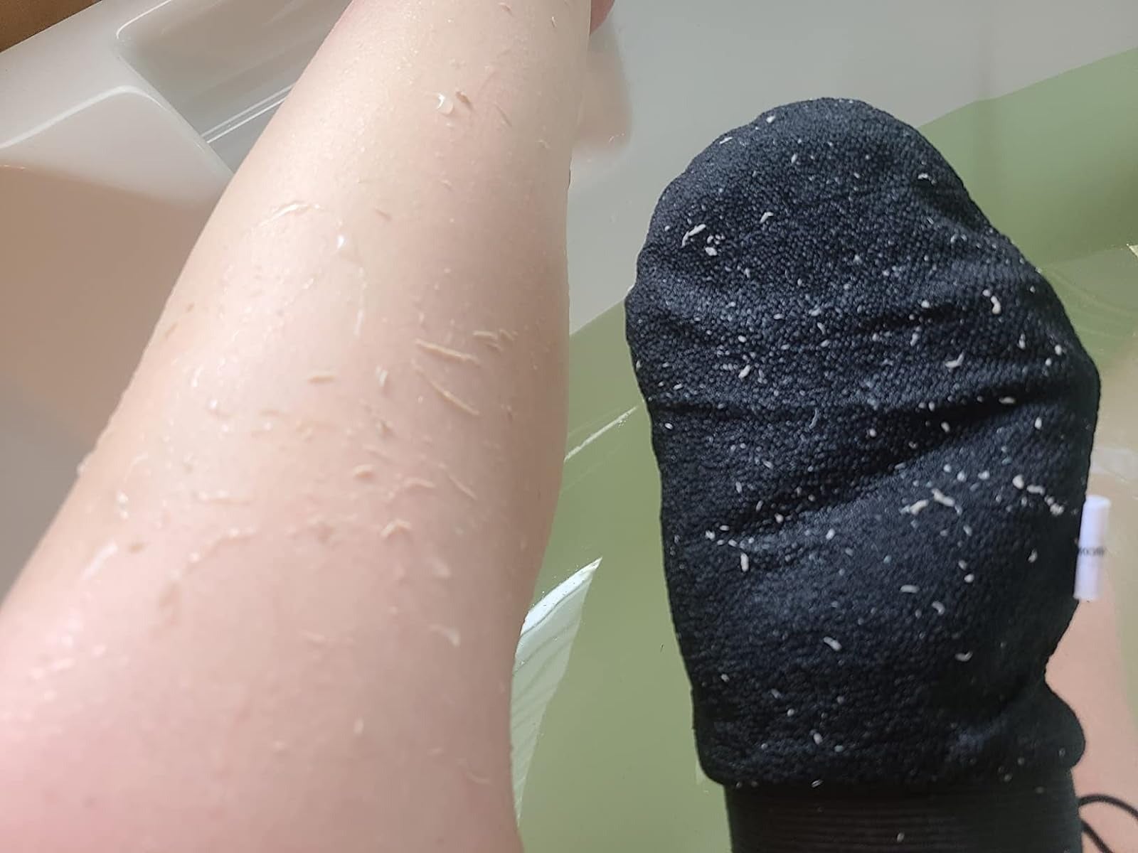 the reviewer removing dead skin with the mitt