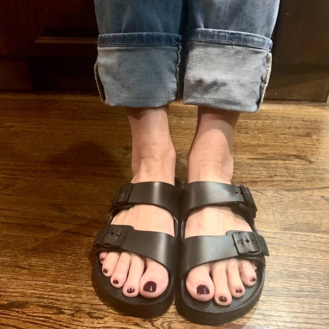reviewer in the black two-strap slides