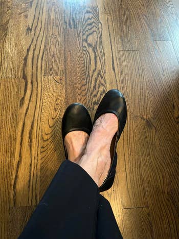 Person wearing achromatic  ballet flats, crossed legs 