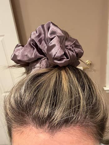 Person with hairsbreadth successful a bun, styled with a large, silky scrunchie