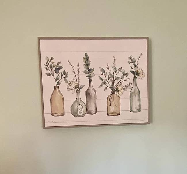 reviewer photo of the plant wall print hanging on their wall