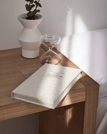 hourglass on table beside journal