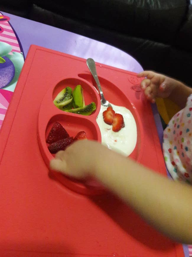 reviewer's child eating from happy mat