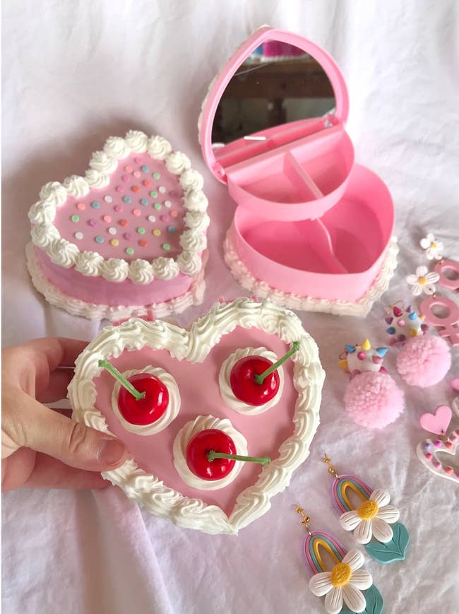 three heart shaped cake jewelry boxes with earrings around them