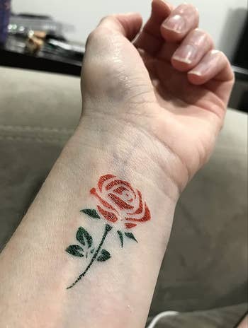 Reviewer with a red and green rose painted on their forearm 