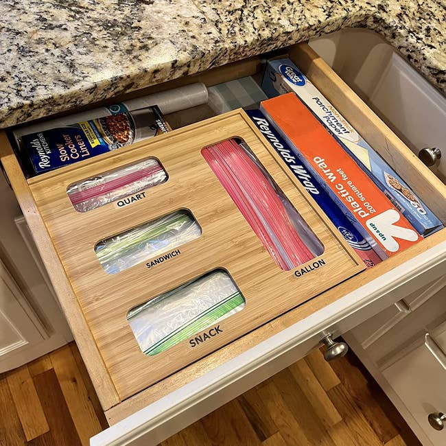 the organizer in someone's kitchen drawer with labels for quart bags, sandwich bags, snack bags, and gallon bags
