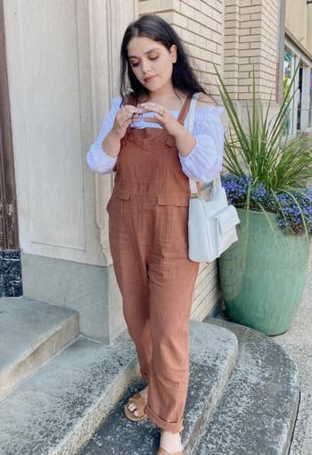 reviewer in brown baggy overalls