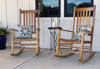 Reviewer image of two natural wooden rocking chairs with slatted backs between a side table with white candles