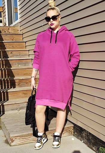 reviewer wearing the pink hoodie dress with sneakers