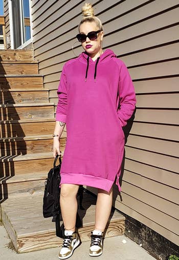 reviewer wearing the pink hoodie dress with sneakers