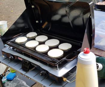 Reviewer pic of small round pancakes on a griddle 
