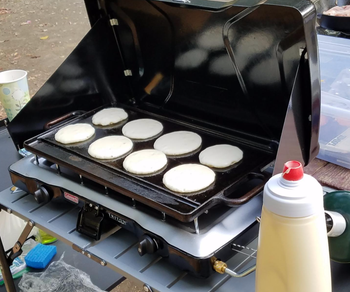 Reviewer pic of small round pancakes on a griddle 