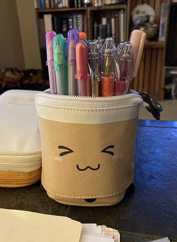the boba tea holder holding a variety of pens