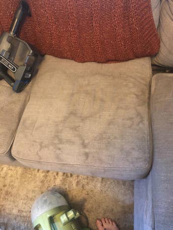 Before of a reviewer's couch with a bunch of stains on it