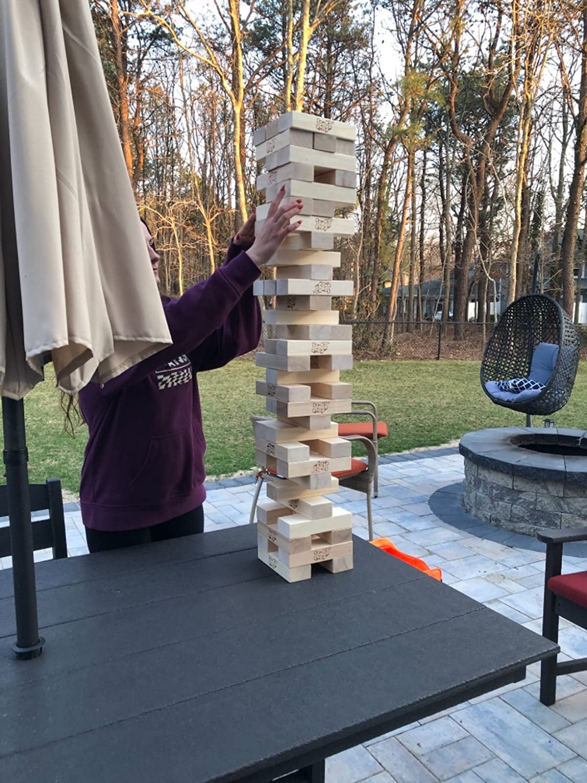 reviewer playing giant jenga in the backyard