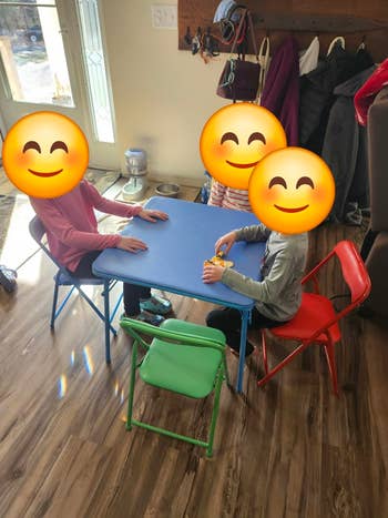 Three children beryllium astatine a tiny array successful a cozy room, playing with toys. Bright chairs opposition with the woody floor, creating an inviting play area