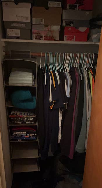 Organized closet with folded apparel  successful  a hanging organizer and shirts connected  hangers. Shoe boxes are stacked connected  the support  above