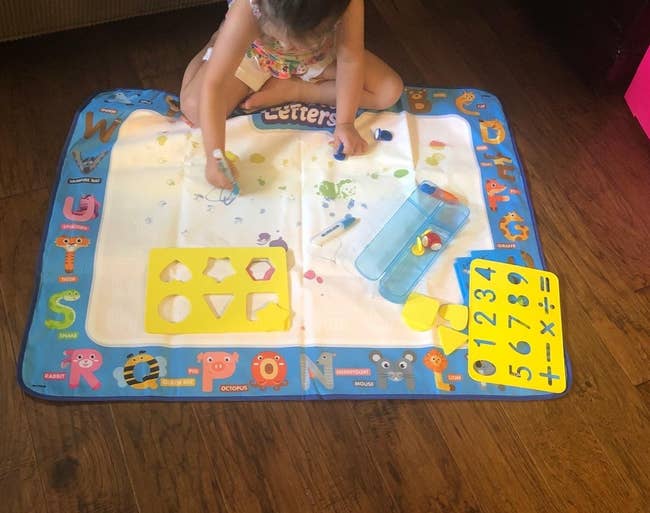 A reviewer's child painting on the mat