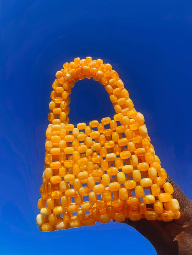 a model holding the bead bag in orange