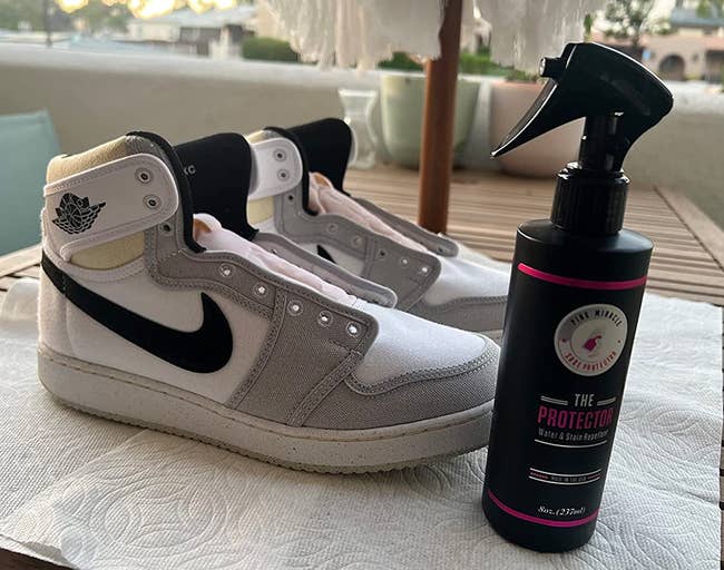 a reviewer photo of a pair of sneakers next to a bottle of the repellant spray 