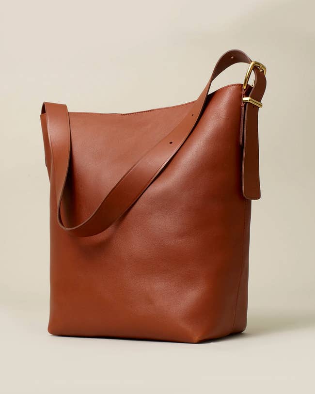 A sleek, minimalist leather tote bag with an adjustable strap, ideal for adding a chic touch to everyday outfits