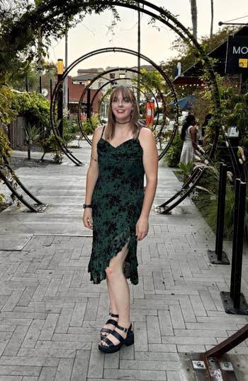 Person successful sleeveless floral-patterned formal and level sandals stands connected a stylish outdoor way with creator archways and thenar trees