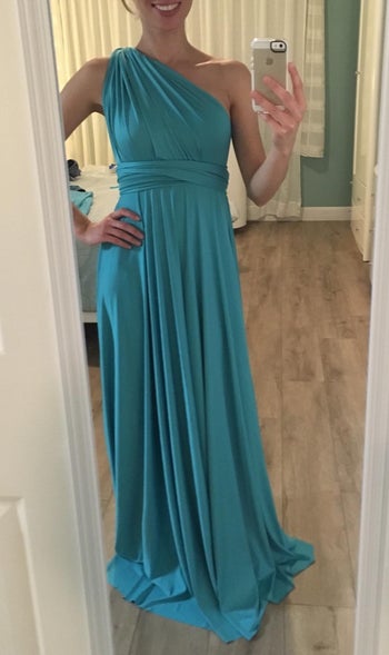 reviewer wearing the teal dress as a one shoulder dress