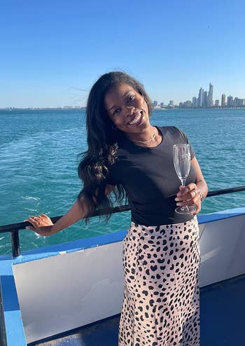 reviewer on a boat wearing a black shirt over the leopard skirt