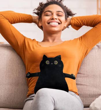 model smiling and relaxed on a couch with a black cat graphic on her shirt